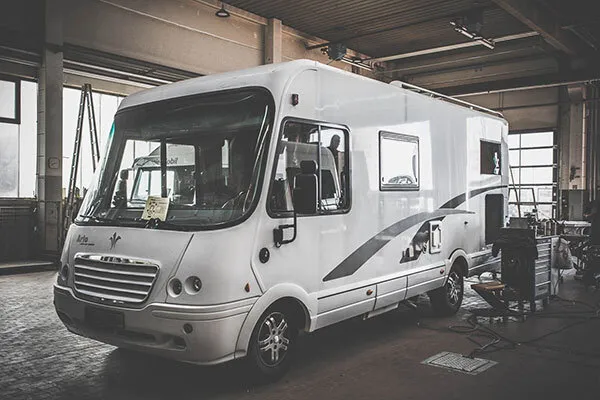 Bild zeigt die Reparatur eines Wohnmobils in großer Werkstatthalle