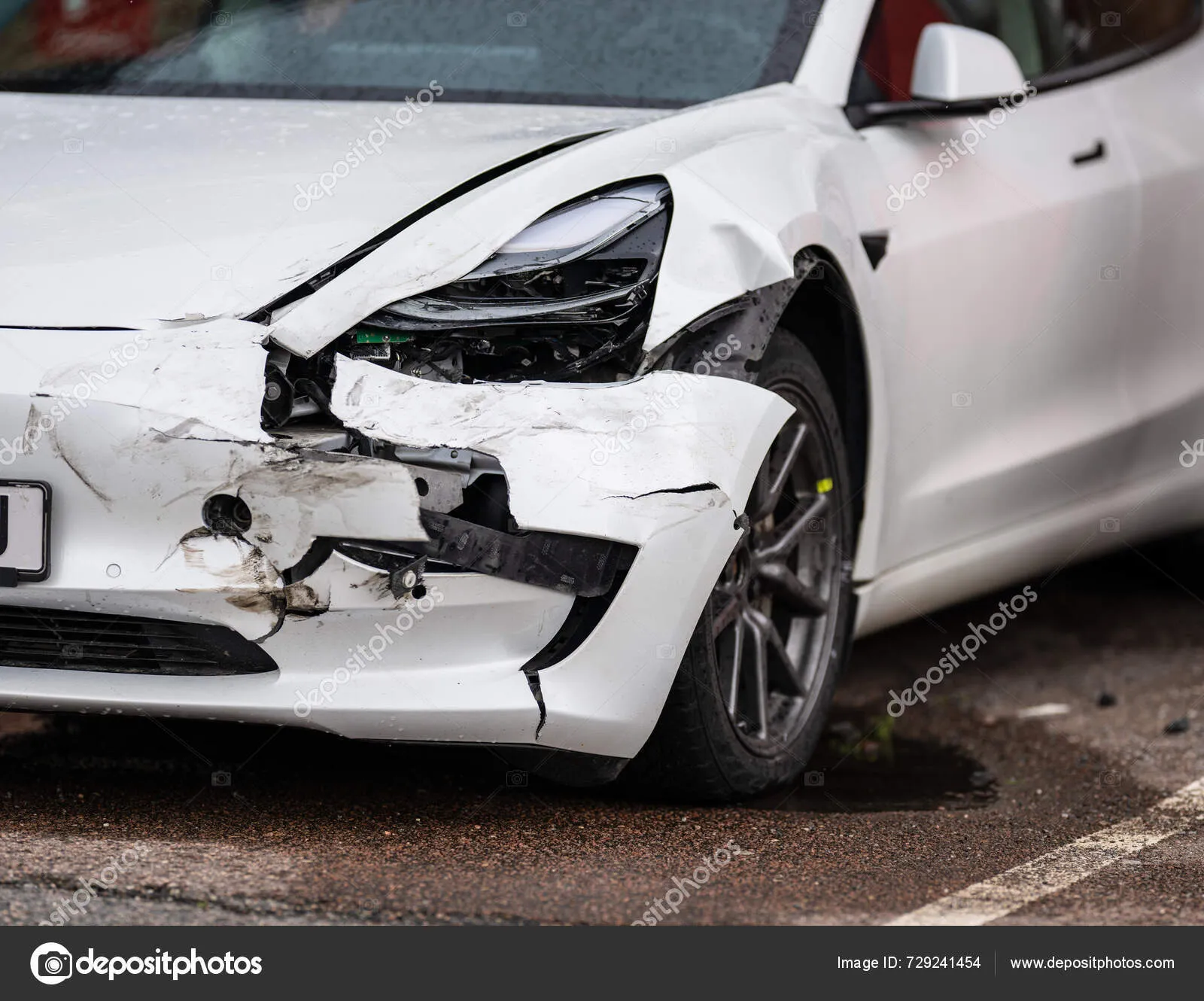 Das Bild zeigt den durch einen Unfall beschädigten Kunststoff-Kotflügel und Vorderteileines Teslas