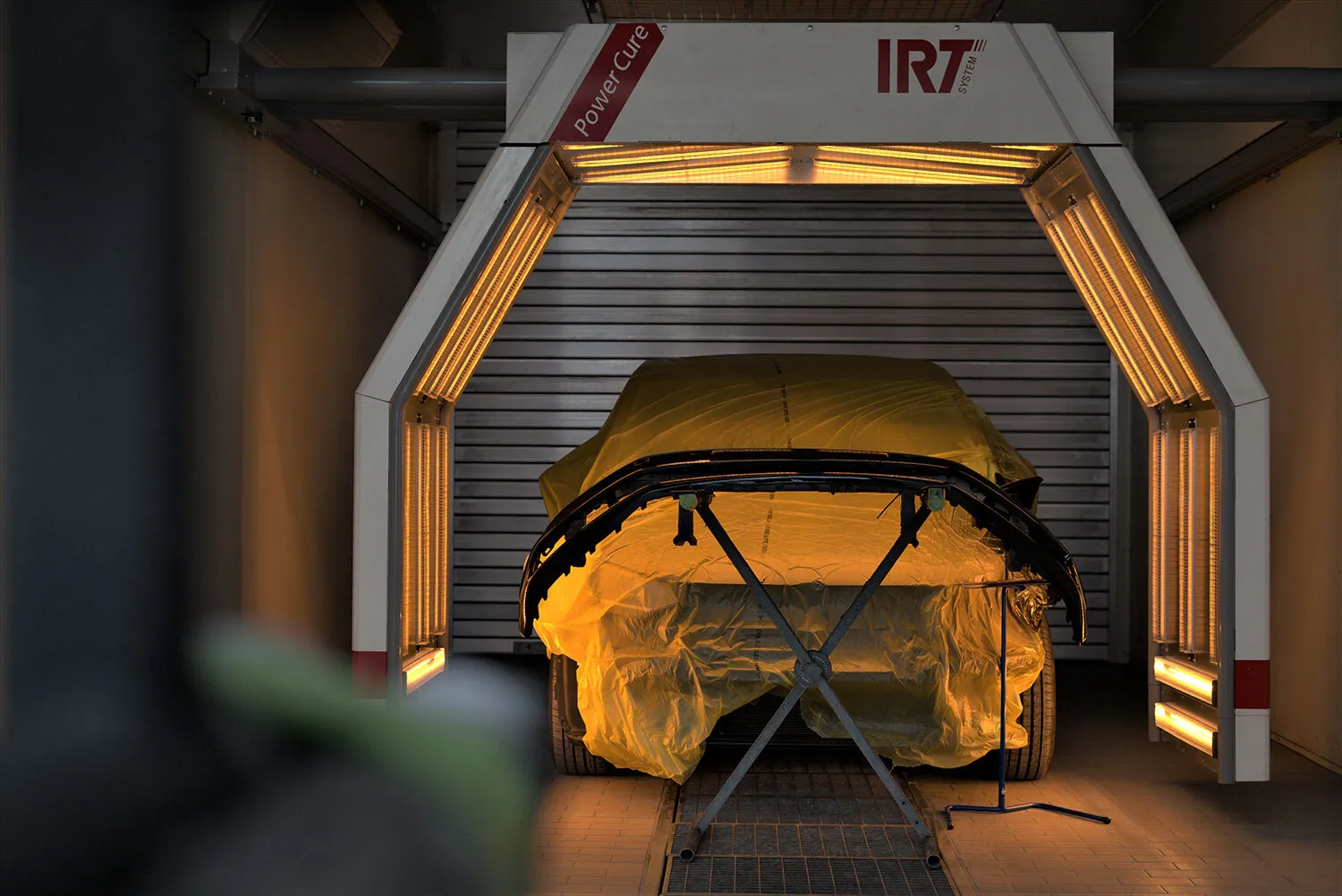 Bild zeigt eine Lackierbox, in der ein Fahrzeug nach dem Lackieren zum schnelleren Lacktrocknung unsere RT Power Cure Infrarot-Bogens eingesetzt wird